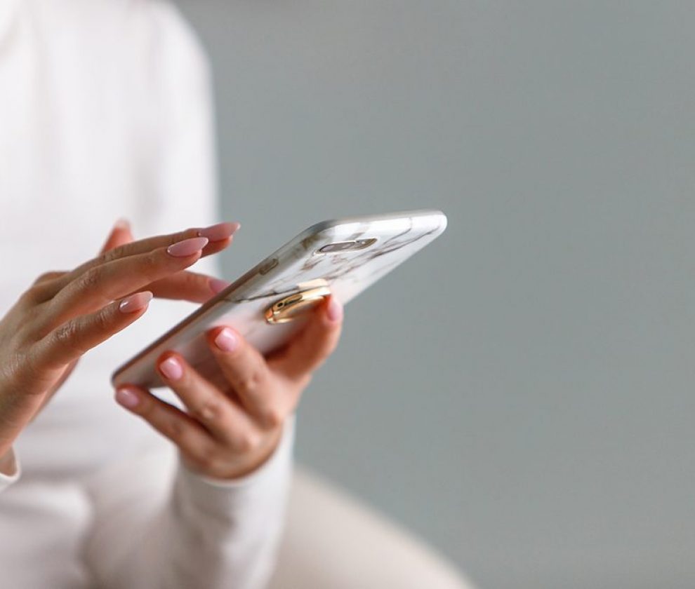 female hands typing text message, using modern smartphone device